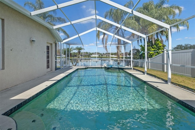 view of pool featuring a lanai, a pool with connected hot tub, fence, and a patio