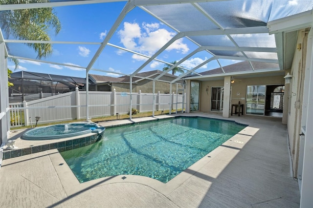 view of pool featuring a pool with connected hot tub, a lanai, a patio, and fence