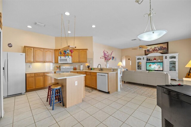 5117 Spectacular Bid Dr, Wesley Chapel, FL 33544 - kitchen with white appliances, arched walkways, open floor plan, and light countertops