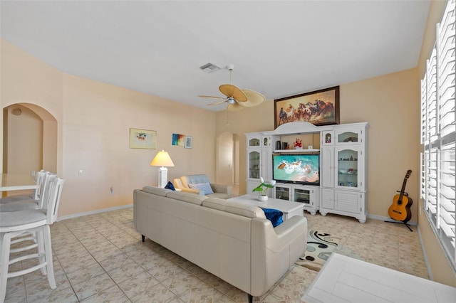 5117 Spectacular Bid Dr, Wesley Chapel, FL 33544 - living area with arched walkways, a ceiling fan, light floors, and baseboards