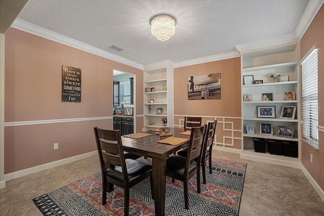 dining area with a textured ceiling, baseboards, visible vents, and built in features