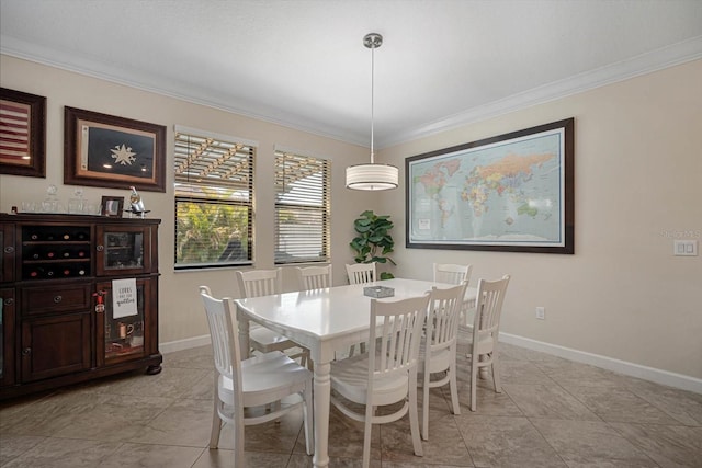 dining space with baseboards and crown molding