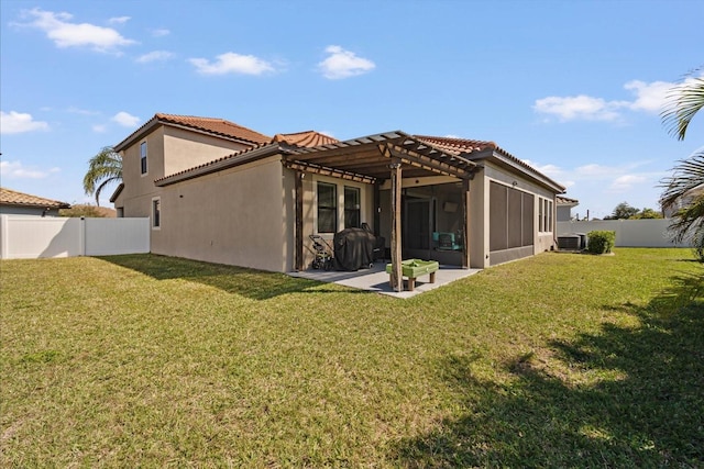 rear view of house featuring stucco siding, a lawn, a patio area, cooling unit, and a fenced backyard