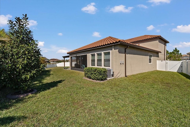 back of property featuring a fenced backyard, a yard, a tiled roof, a gate, and stucco siding