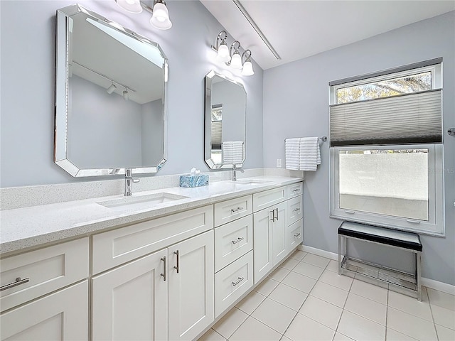 full bathroom featuring tile patterned flooring, a sink, baseboards, and double vanity