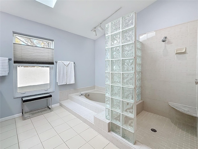 bathroom with a walk in shower, tile patterned flooring, a garden tub, baseboards, and rail lighting