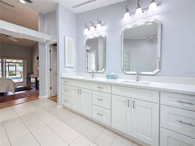 ensuite bathroom featuring double vanity, tile patterned flooring, connected bathroom, and a sink