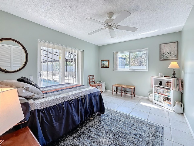 tiled bedroom featuring a ceiling fan, baseboards, and a textured ceiling