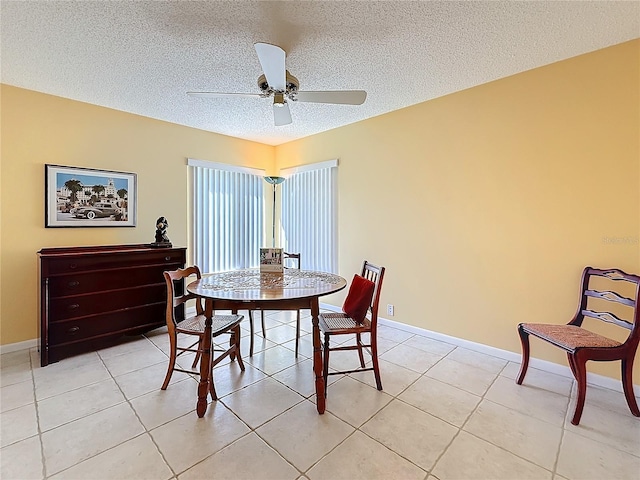 dining room featuring a textured ceiling, ceiling fan, light tile patterned flooring, and baseboards