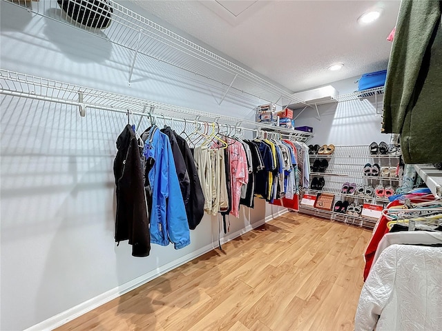 walk in closet with wood finished floors