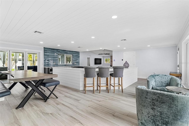 dining room featuring light wood-style floors, visible vents, ornamental molding, and recessed lighting