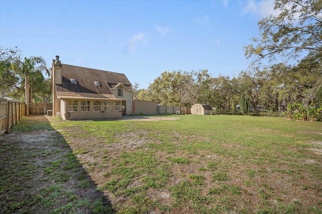 view of yard with a fenced backyard, an outdoor structure, and a shed