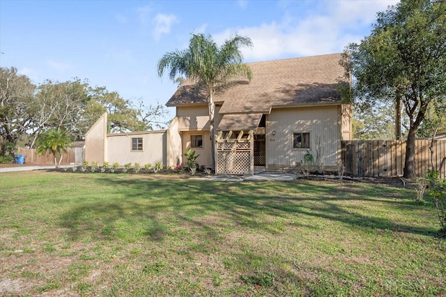 view of front of home with a front yard and fence