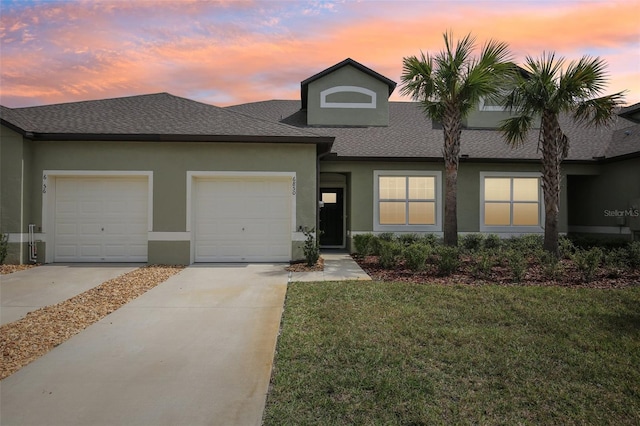 view of front of house featuring concrete driveway, a front yard, an attached garage, and stucco siding