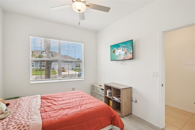 bedroom with ceiling fan, light tile patterned floors, and baseboards