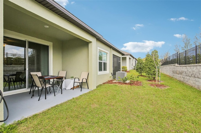 view of yard featuring fence, a patio, and central AC unit