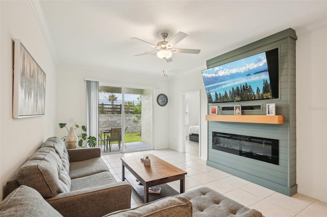 living room featuring light tile patterned floors, ceiling fan, a fireplace, and ornamental molding