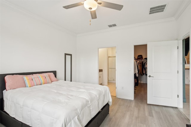 bedroom with visible vents, a walk in closet, and crown molding