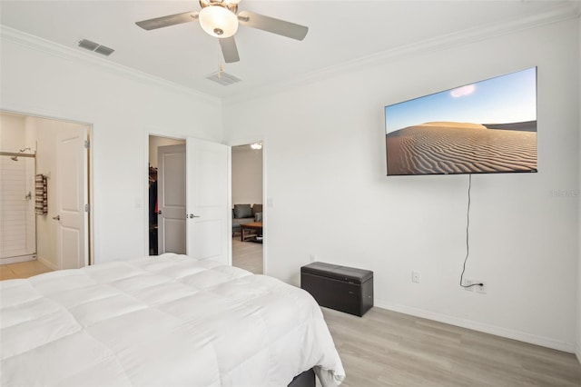 bedroom with wood finished floors, visible vents, and crown molding