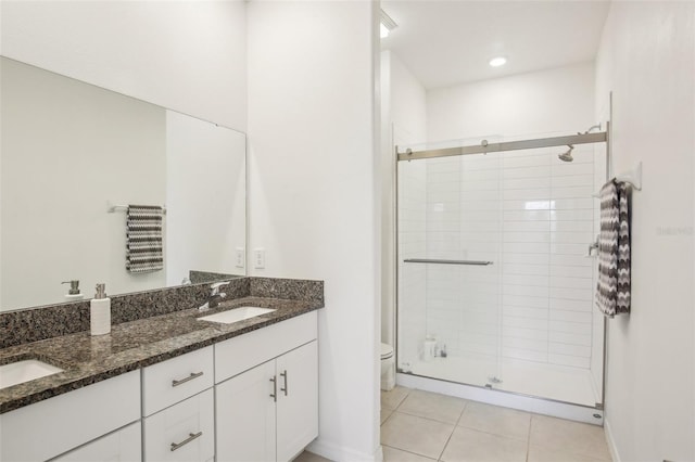 full bath with a stall shower, tile patterned flooring, a sink, and toilet