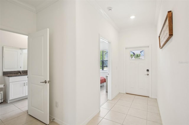 foyer featuring light tile patterned floors, baseboards, and crown molding