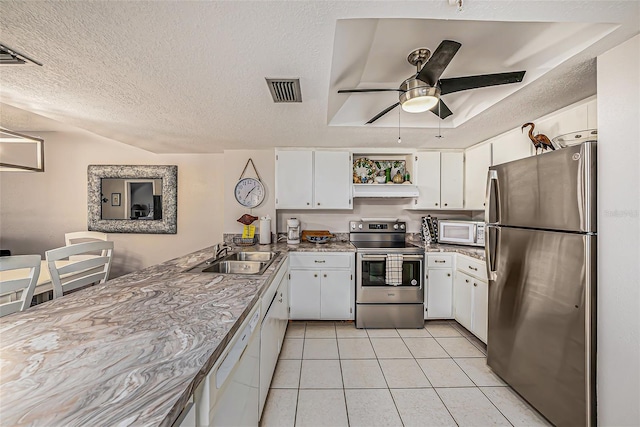 kitchen featuring a sink, a textured ceiling, light tile patterned floors, and stainless steel appliances