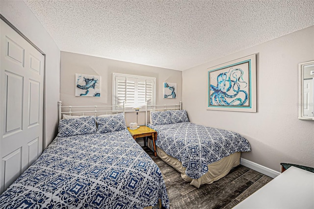 bedroom featuring a textured ceiling, baseboards, and wood finished floors