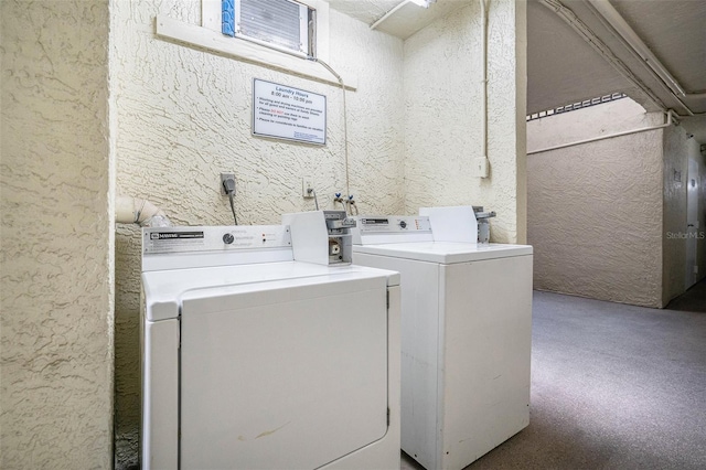 community laundry room featuring a textured wall and washer and clothes dryer