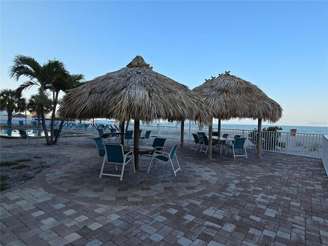12924 Gulf Blvd Unit 110, Saint Petersburg, FL 33708 - view of patio / terrace with outdoor dining space, a community pool, and a water view