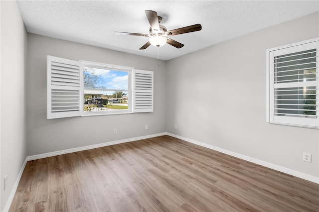 spare room with baseboards and wood finished floors