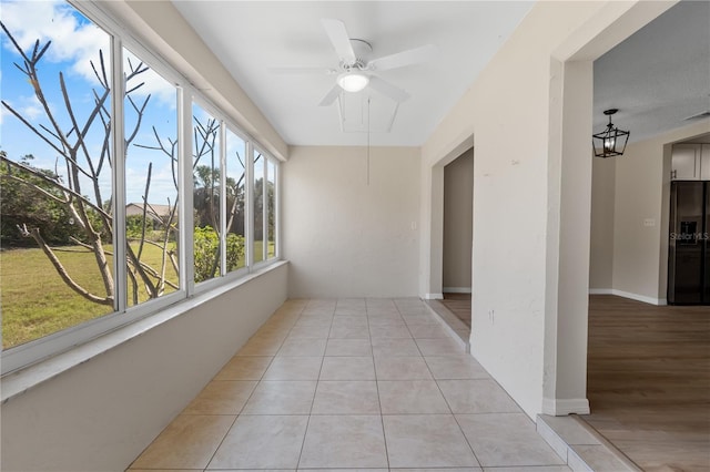 unfurnished sunroom featuring ceiling fan