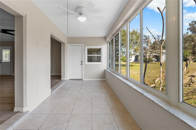 unfurnished sunroom with ceiling fan