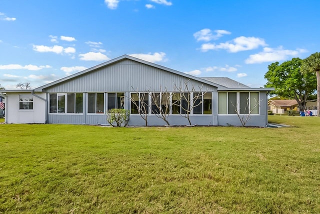 back of house with a sunroom and a yard