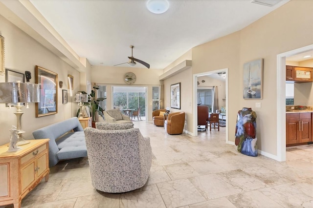 sitting room with marble finish floor, a ceiling fan, and baseboards