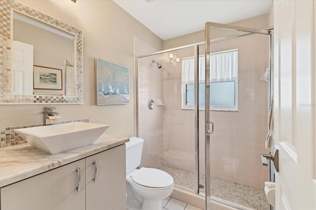 full bath with a stall shower, tile patterned flooring, vanity, and toilet