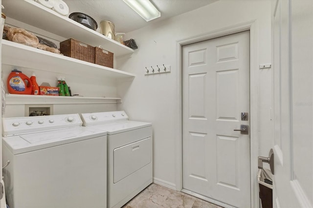 washroom with marble finish floor, laundry area, washing machine and clothes dryer, and baseboards