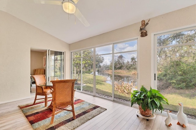 sunroom featuring lofted ceiling, plenty of natural light, and a water view