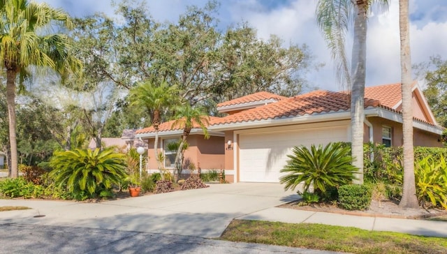 4579 Del Sol Blvd S, Sarasota, FL 34243 - mediterranean / spanish house featuring an attached garage, concrete driveway, stucco siding, and a tile roof