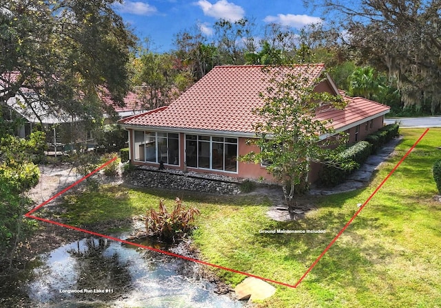 4579 Del Sol Blvd S, Sarasota, FL 34243 - rear view of property featuring a yard, stucco siding, and a tiled roof