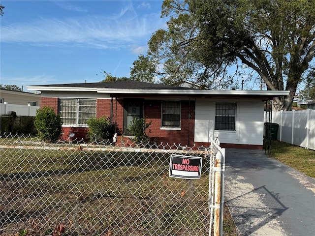 view of front of property featuring a fenced front yard, a front yard, and brick siding