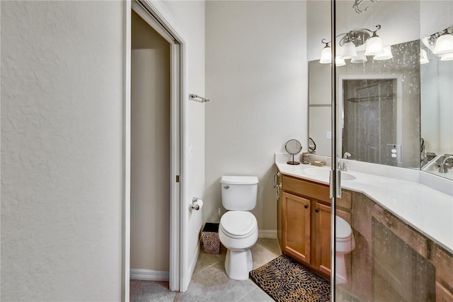 bathroom with toilet, baseboards, vanity, and tile patterned floors