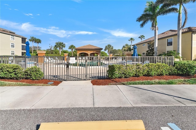 view of home's community with a pool, playground community, fence, and a gazebo