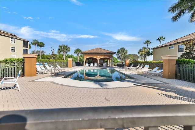 community pool featuring a patio area, fence, and a gazebo