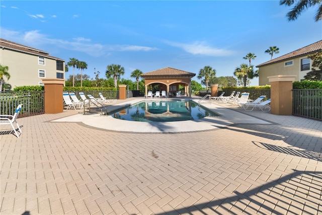 community pool featuring a patio area, fence, and a gazebo