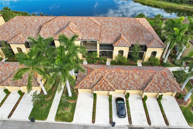 view of front of house with a water view, a tiled roof, and stucco siding