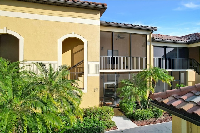 view of exterior entry featuring a tile roof and stucco siding