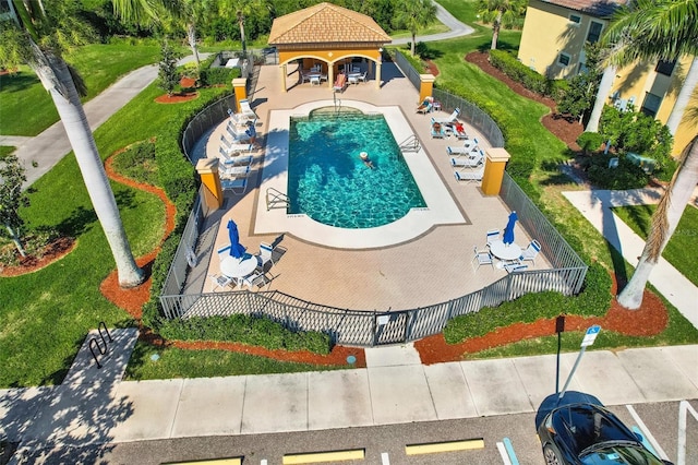 community pool with a patio area and fence