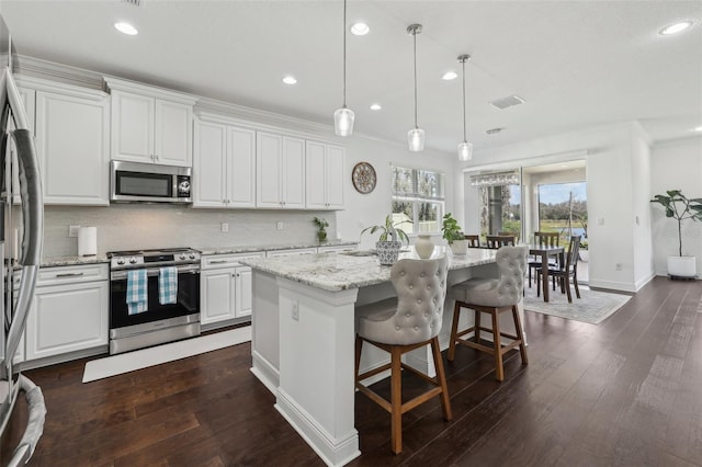 kitchen with dark wood-style floors, appliances with stainless steel finishes, backsplash, and visible vents