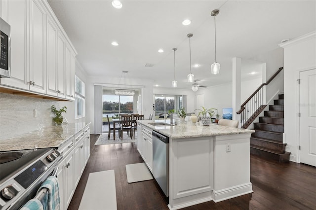 kitchen featuring stainless steel appliances, a sink, white cabinetry, backsplash, and dark wood finished floors