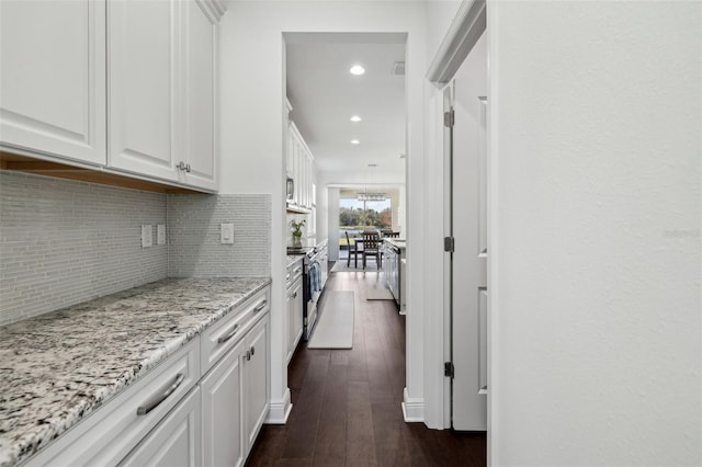 kitchen featuring dark wood-style flooring, stainless steel electric stove, backsplash, white cabinets, and light stone countertops